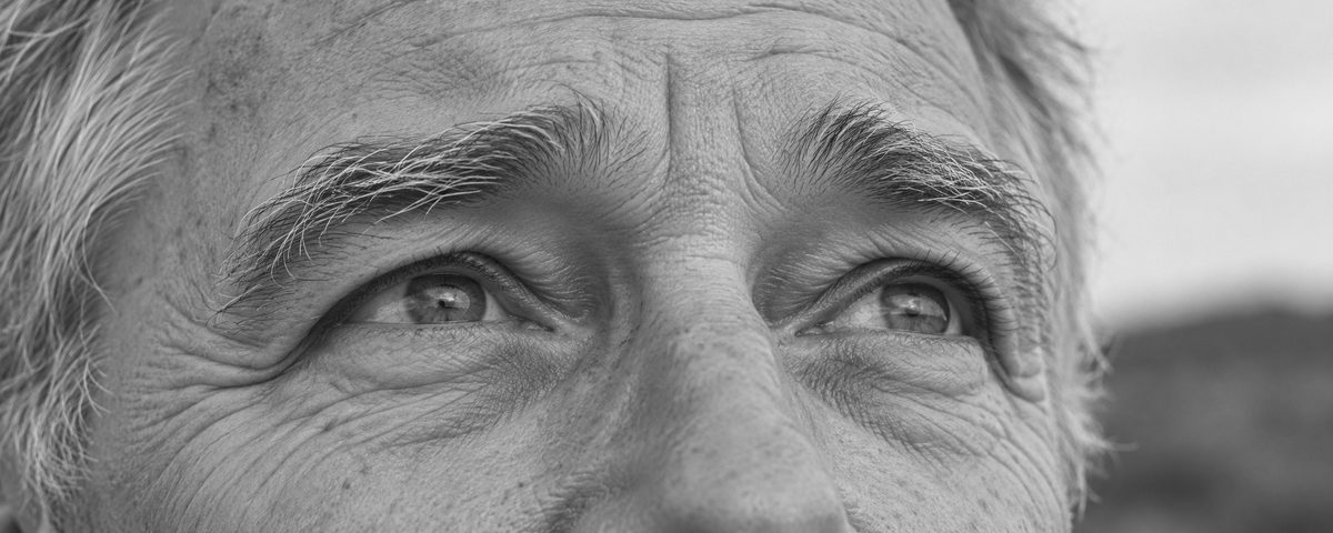 An older man's eyes, looking up and to the side